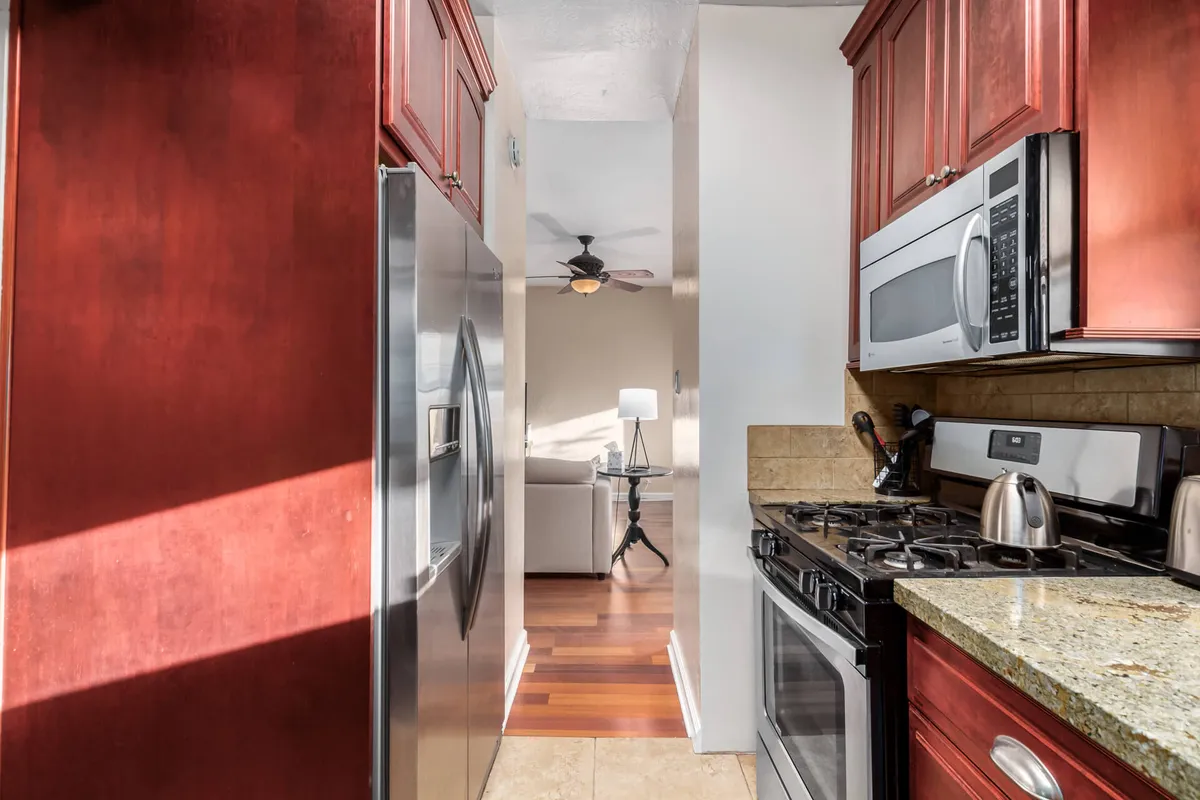 A welcoming kitchen with stainless steel appliances, granite countertops, and warm natural light flowing in from the living area. The space is arranged for cooking, entertaining, and family gatherings, inviting guests to make lasting memories.