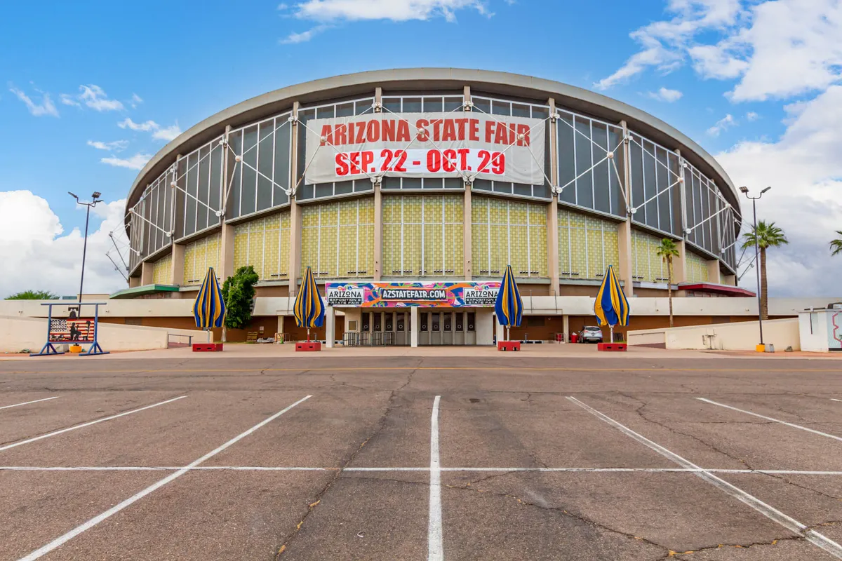 Featuring the Arizona State Fair banner, colorful flagpoles, and the bustling entrance to a popular local venue, this image vibrantly represents the excitement and energy of local events and attractions.